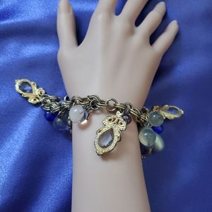 Vintage women's charm bracelet.  Brass chain with beads, gold trinkets